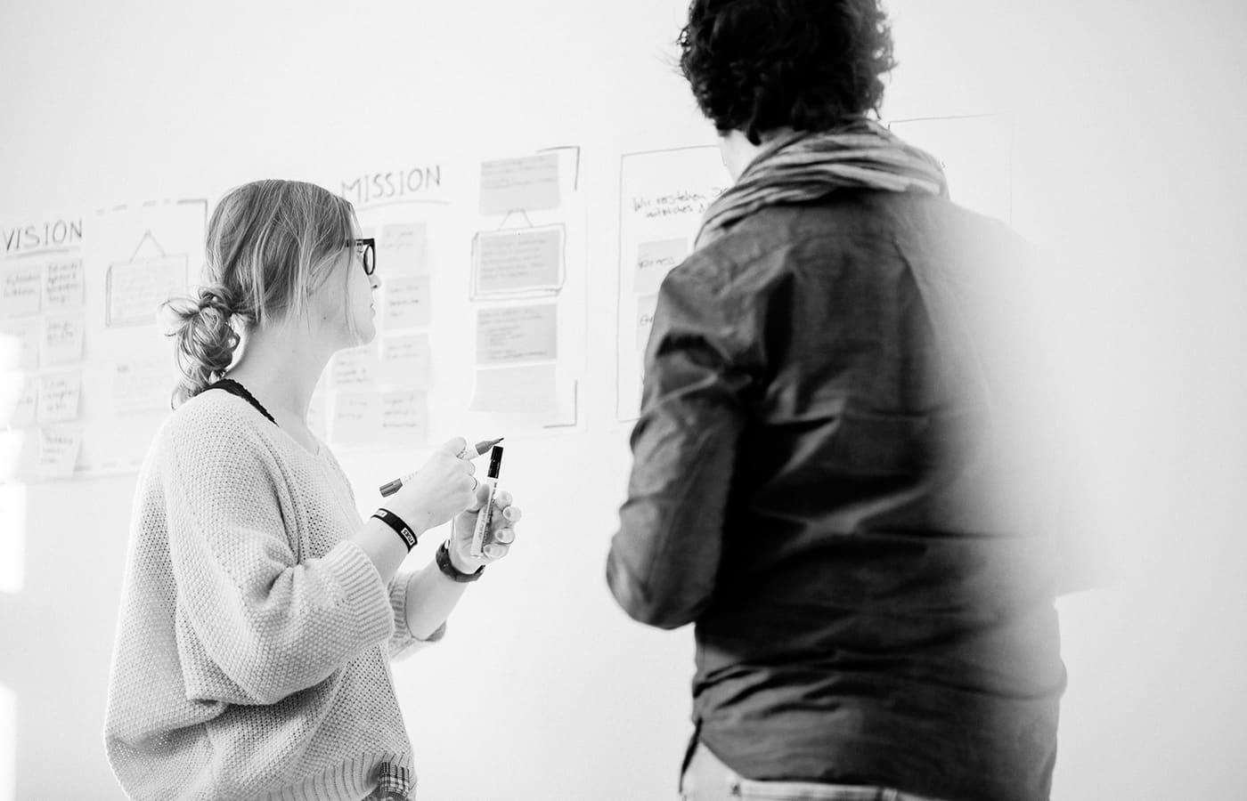 Impression aus einer internen Workshop mit der Geschäftsführung vor einer Wand mit Notizzetteln